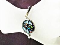 Close-up view of the bracelet on display, highlighting the colorful "The Bear" medallion.
