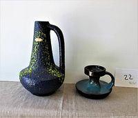 Full view of both items, pitcher on left and candle holder on right.