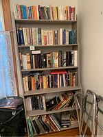 Full view of five-tier bookshelf filled with assorted books