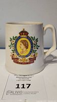 Front side of the mug showing the Queen Elizabeth II portrait with crest and banner.