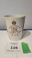 Porcelain cup front side with crowned monogram and coronation text.