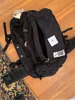 Photo of black travel backpack with Europe Bound logo and straps visible on wooden floor