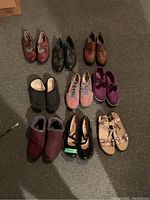 Nine pairs of women's size 41 shoes arranged in three rows on a carpeted floor, various styles including casual, athletic, dress, and sandals.