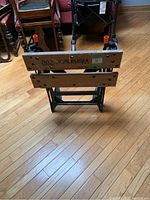 Front view of adjustable work bench showing wooden clamp boards and metal frame.