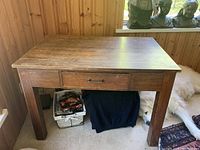 Front view of antique solid wood school desk with one visible drawer and sturdy rectangular legs.