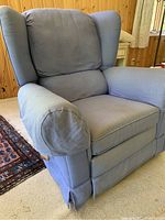Front view of oversized blue upholstered swivel rocker recliner chair with wingback and cushioned armrests.