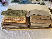 Folded assorted fabric scraps in neutral and earth tones with different textures and materials
