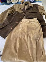 Ralph Lauren Hunter jacket in brown and beige with Eddy Bauer beige suede skirt laid flat showing fabric texture and buttons