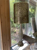 Full view of MCM lamp showing tall base and textured lampshade on a windowsill with natural light.