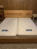 Display of the ash wood twin bed frame assembled with two twin mattresses to show fit and size. Close view of mattress placement and headboard storage visible.