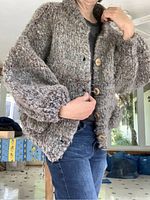 Woman wearing chunky heather wool cardigan sweater with wood buttons, showing fit and texture.