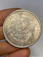 Obverse side showing the eagle with outstretched wings holding arrows and olive branch, inscribed with 'UNITED STATES OF AMERICA' and 'ONE DOLLAR'.