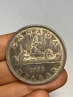 Reverse side showing voyageur in canoe design and coin information.