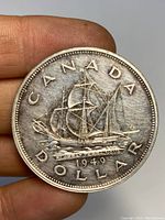 Front side of the coin showing the ship and inscription 'CANADA DOLLAR 1949'.