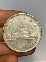 Obverse side of the 1953 Canadian silver dollar coin showing the canoe design with two paddlers and the year 1953.