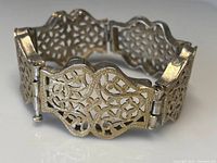 Bracelet showing the full curved panel design and clasp mechanism.