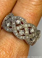 Close-up photo showing the detailed silver work and five small genuine diamonds on the ring worn on a finger.