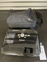 Top view of Epson projector with control buttons and carrying case