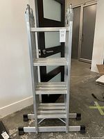 Folded view of the Mastercraft aluminum multi-position ladder showing the front with four steps visible and rubber feet on supports.