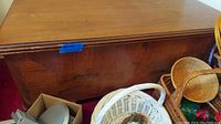 Front view of cedar chest showing wood surface and general shape with push-button closure and no visible keyhole.