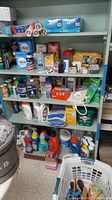 Shelf displaying cleaning products, tissues, Ziploc bags, Con-Tact paper, and other household items.