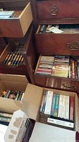 View of multiple dresser drawers filled with VHS tapes, CDs, and cassettes along with boxes containing additional tapes.