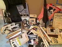 Overview of assorted items on floor including jacket, cutout, umbrella, posters, playbills, headshots, snow globes