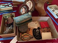 Wide view of the lots inside boxes showing estate pipe case, antique shoes, vintage portrait prints, and other ephemera items.