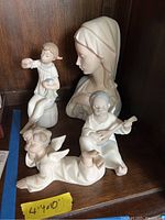 All four porcelain figurines displayed together on shelf