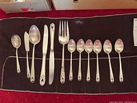 Full set of twelve flatware pieces laid out on protective roll