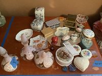 Photo showing the full assortment of bottles, trinket boxes, and dish on a wood surface.