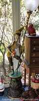 Full front view of the pixie lamp showing base, figurine and globe shade