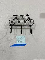 Front view of the metal bicycle-shaped key holder showing three hooks and detailed bicycle parts.