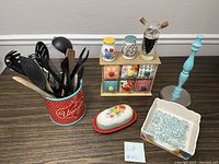 Overview of kitchen set showing utensil holder with utensils, miniature drawer set, butter dish, spice jars, oil dispenser, and candlestick holder.