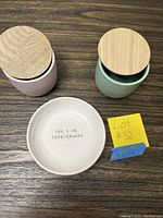 Overview of the ceramic plate and two jars on a wooden surface with a yellow lot sign.