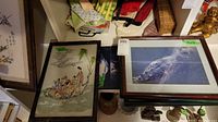 Two framed Asian art and one large framed bird photograph on shelf