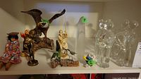 Full shelf view showing all figures including eagle, Asian figures, Smurf, and glass bears