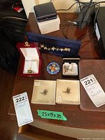 Overall view of 14K necklace, silver bracelet, earrings, tie tacks and boxes on tabletop