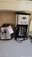 Oster toaster and Cuisinart coffee maker side by side on counter