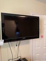 Toshiba 32-inch flat screen TV model 32C120U mounted on wall with cables hanging below, showing front screen and bezel.