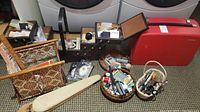 Wide view of lot showing red Bernina carry case, open wooden sewing box with floral lining, two woven baskets, shoe stretchers and other supplies