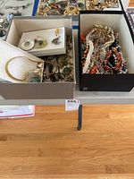 Two boxes of assorted costume jewelry including necklaces, bracelets and earrings