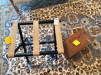 Photo showing mini cedar chest and black luggage rack on patterned rug