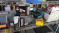 Shelving rack with boxes of Ridgid sanders, blue socket set, and DeWalt drill bit case.
