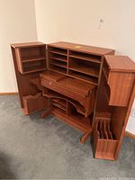 Desk cabinet open front view showing interior shelves and fold-down desk surface