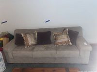 Front view of the sleeper sofa showing fabric, cushions and pillows arrangement.