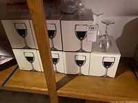 Stacked boxes of six goblets each with box label showing wineglass illustration, actual goblets on top of boxes.