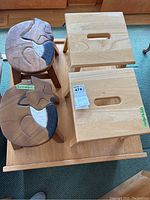 Top view of all four stools showing two fox carved stools and two plain tan wood stools