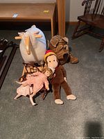 Overview of all items in the lot including two vintage dolls, a sheep rocker, Curious George plush, plush dog, and doll chairs
