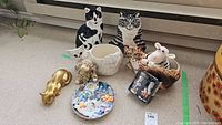 Full lot showing two ceramic cat planters, two cat-themed vases, brass cat door stop, and cat salt & pepper set